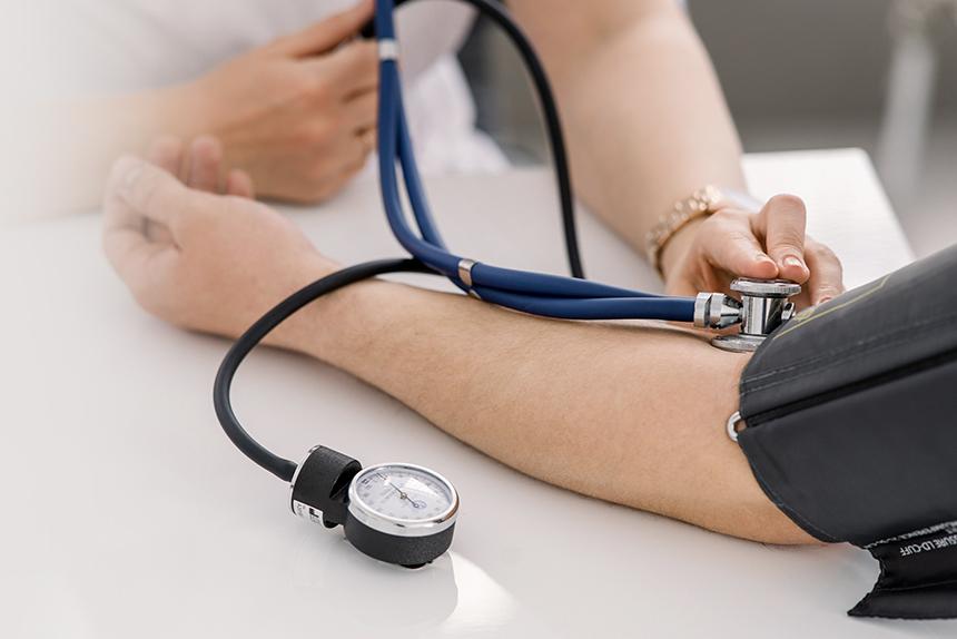 Nurse taking a patient’s blood pressure during a heart disease checkup.