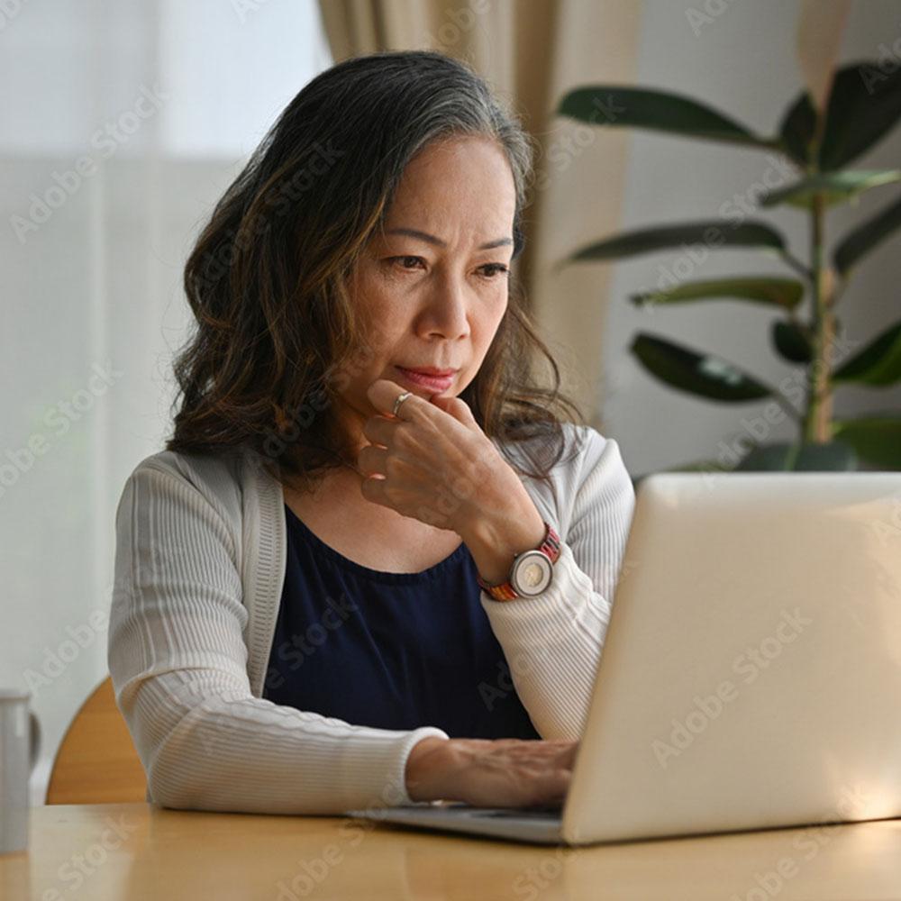 Person looking at a laptop while getting information about screening support