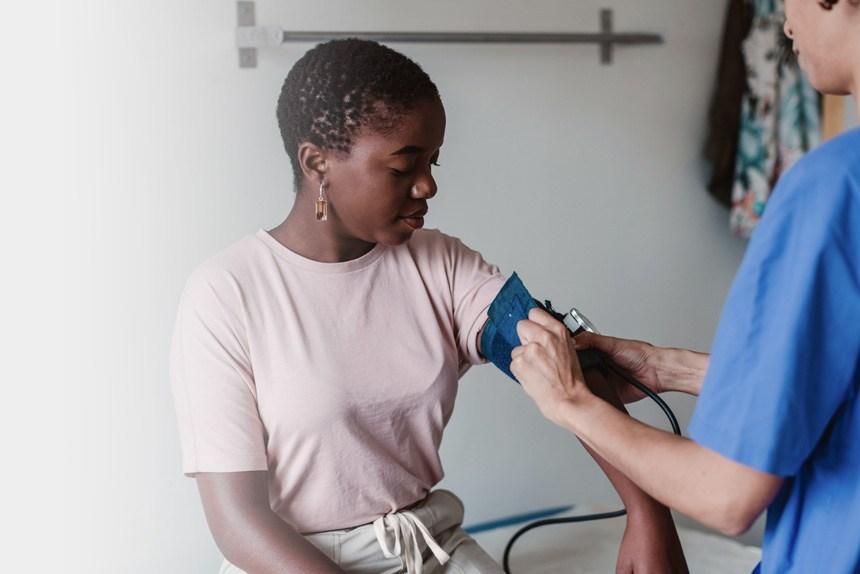 Nurse taking the blood pressure of a female patient