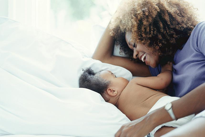 A woman and her baby who are part of the WIC program laying in bed
