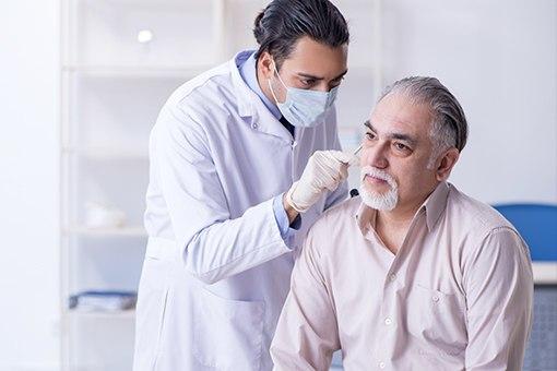 Doctor screening a patient for skin cancer.