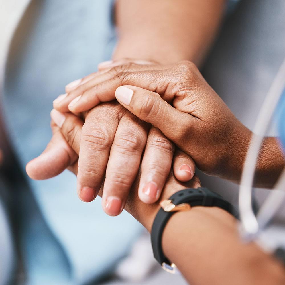 Patient and provider holding hands during treatment support