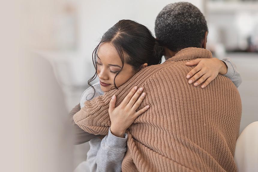 Daughter hugging her dad who is a cancer survivor.